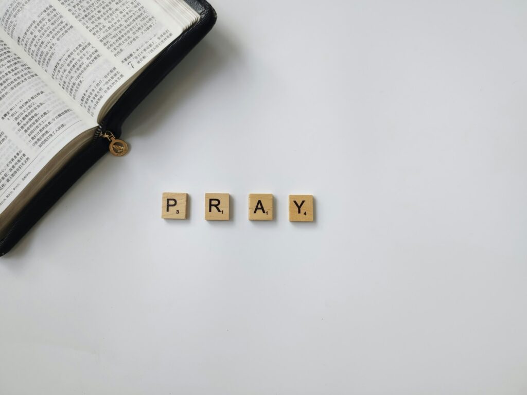 Religious conversations among federal workers now protected under OPM guidance A portion of a Bible is shown with Scrabble tiles spelling PRAY.