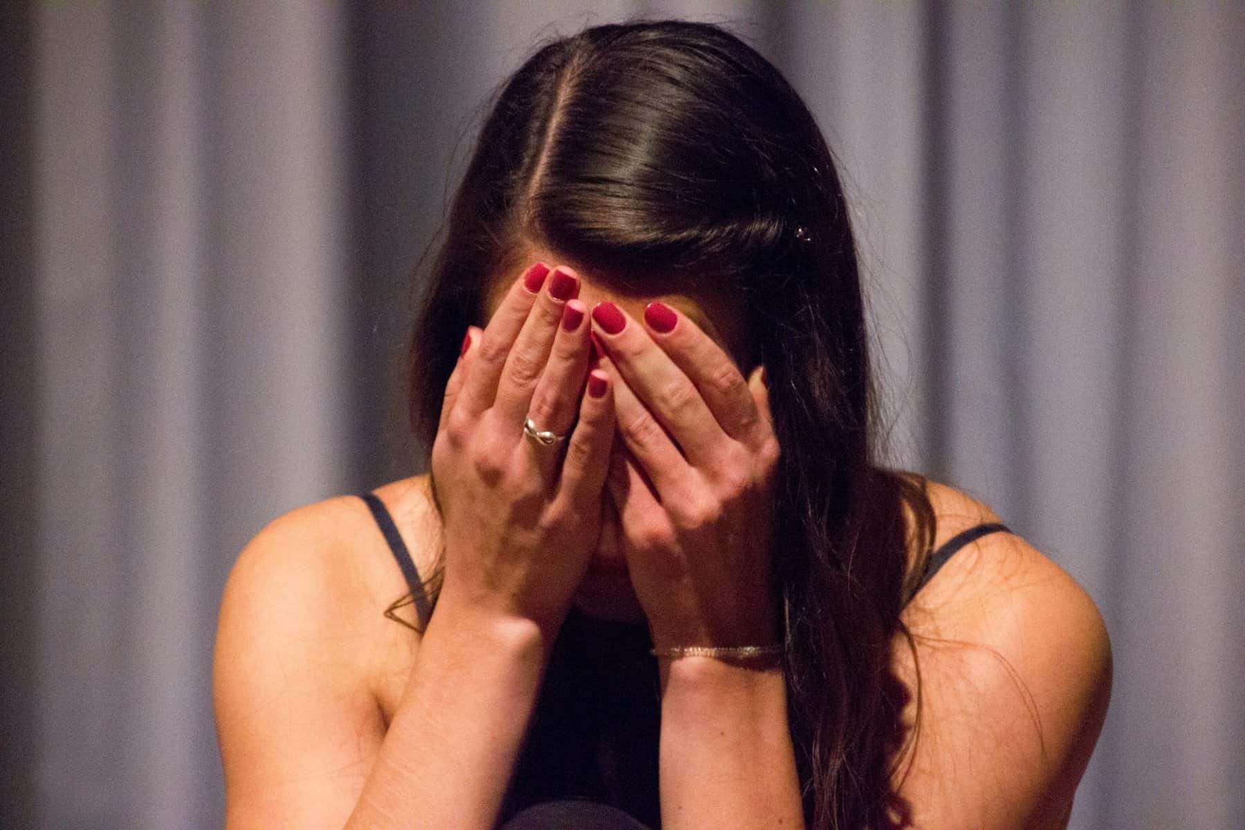 A woman with her face in her hands.