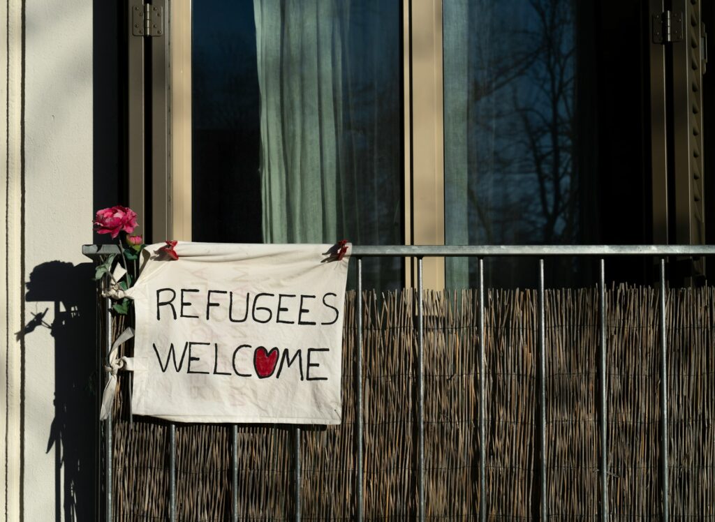 A sign says "Refugees Welcome"