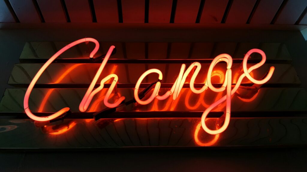 Orange neon sign says "change".