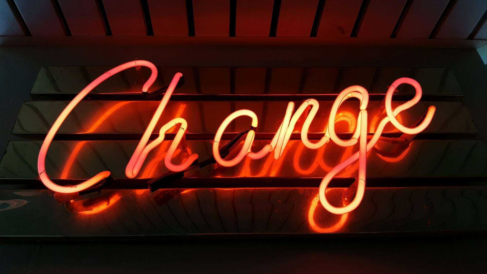 Orange neon sign says "change".
