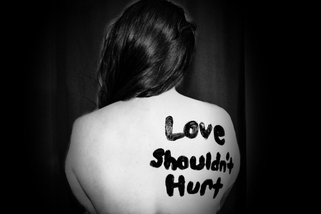 A woman's bare back says Love shouldn't hurt.