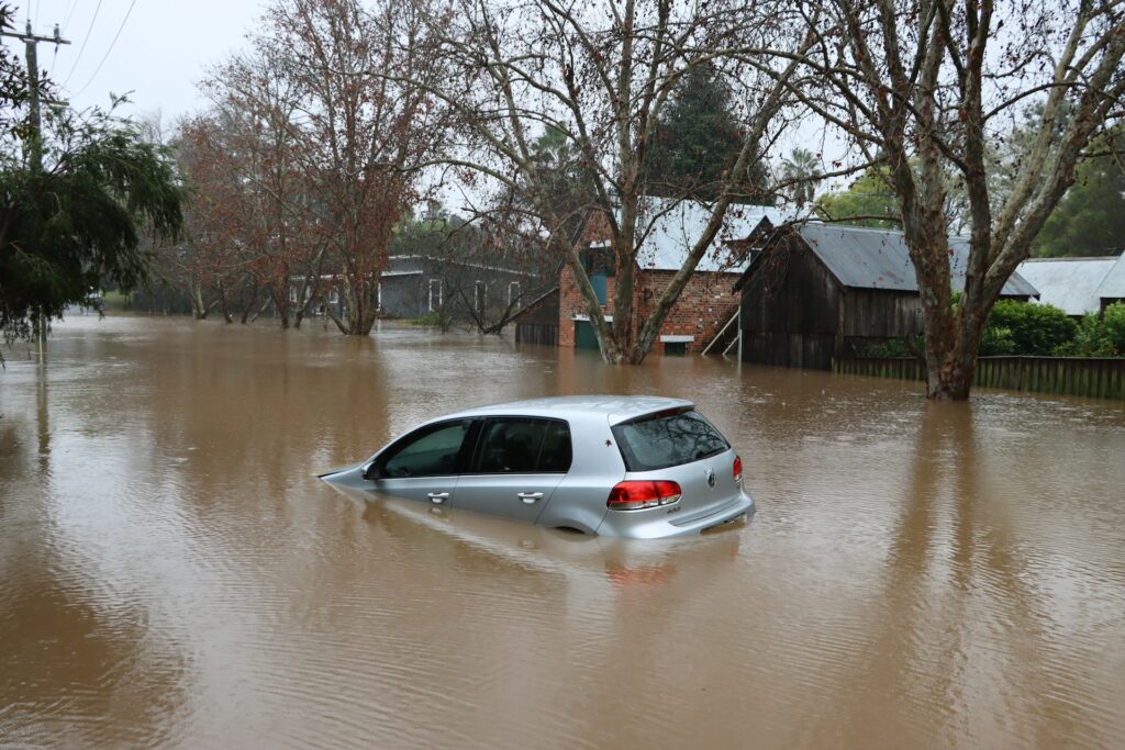 A flooded car on flooded street.