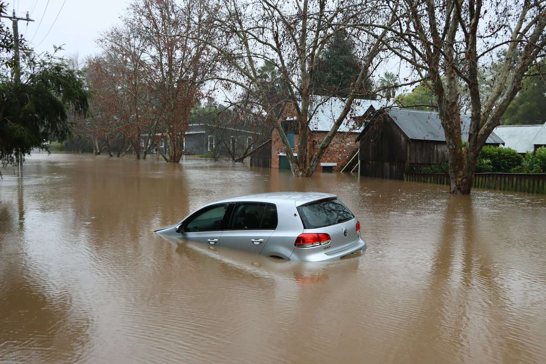 A flooded car on flooded street.