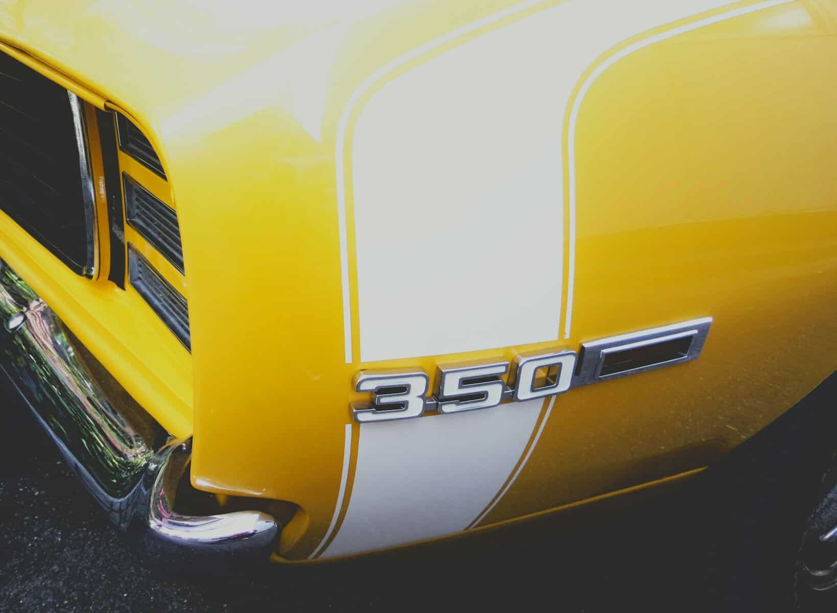 Rear quarter panel of a yellow muscle car.
