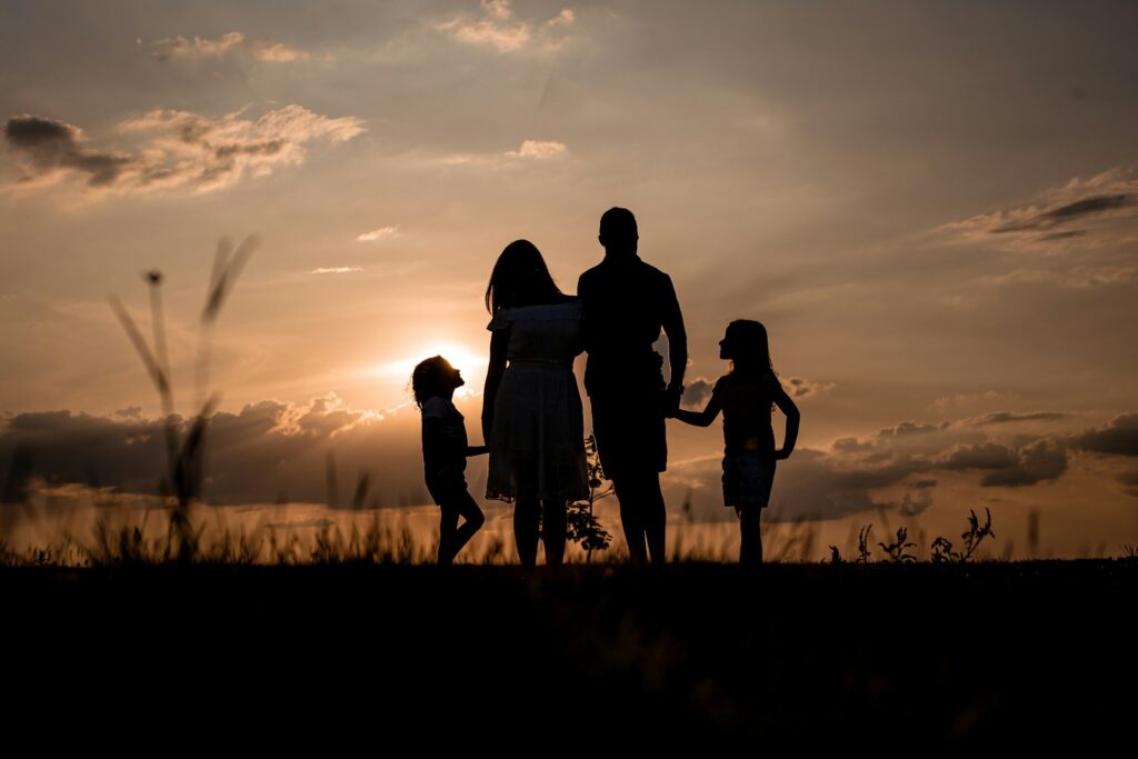 A family in silhouette at sunset.