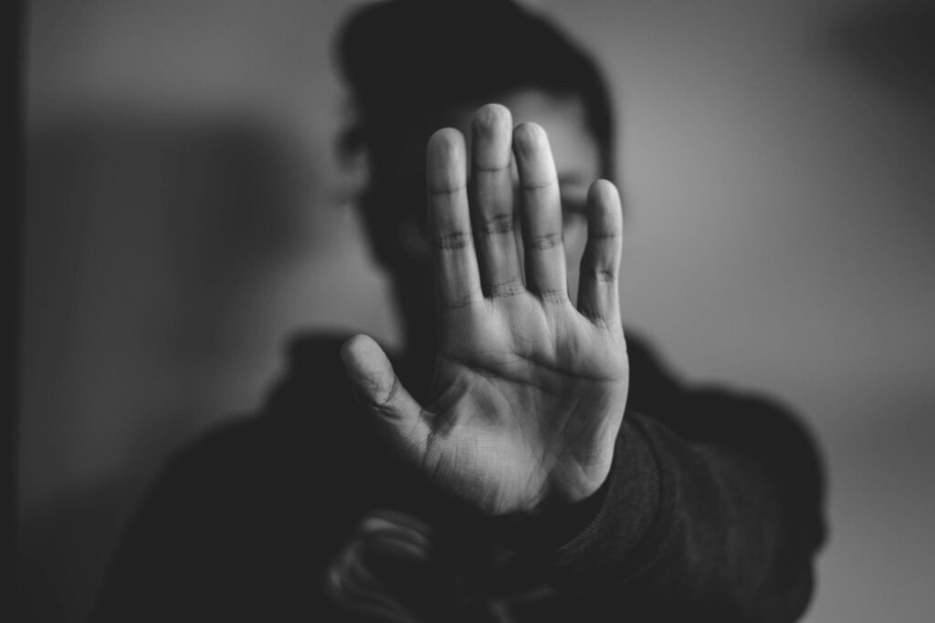 Faith and Reform: The story of ASJ’s anti-violence strategy Black and white image of a woman with her palm up and toward the camera.