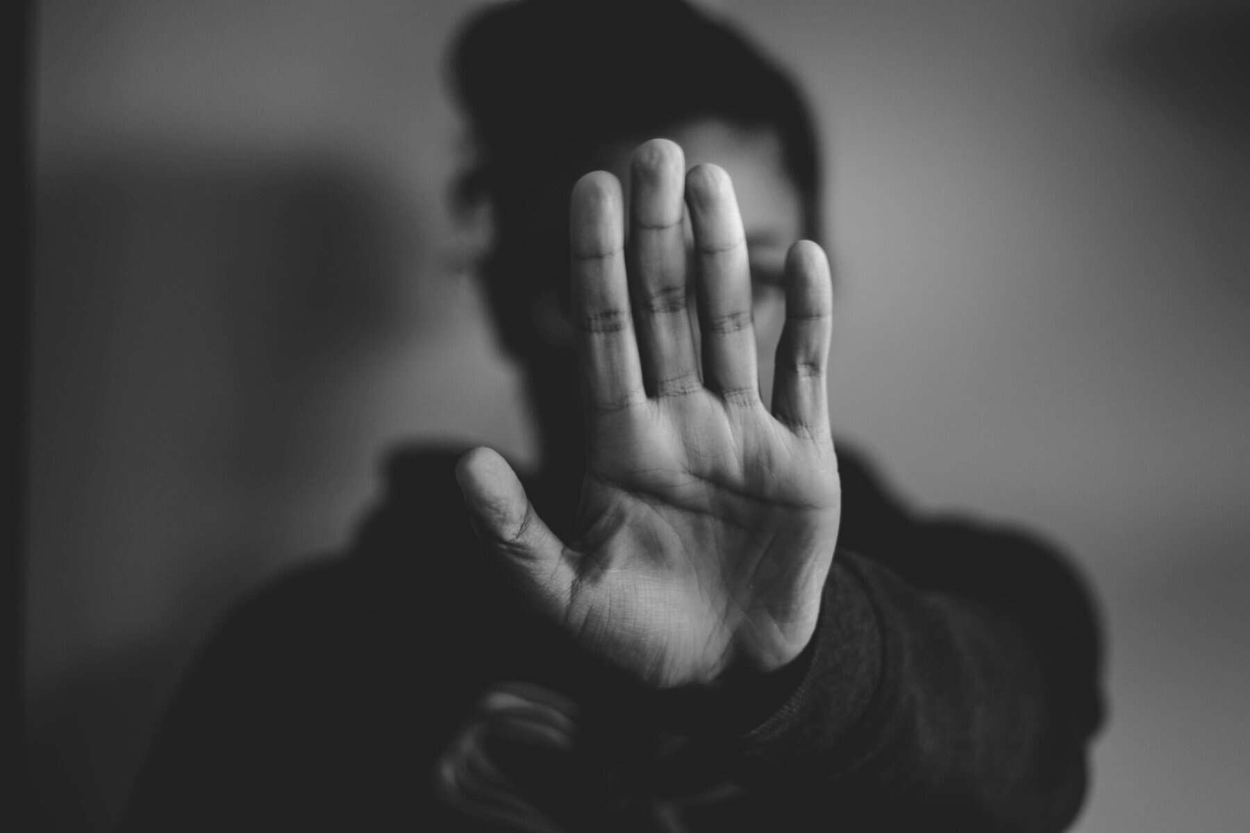 Black and white image of a woman with her palm up and toward the camera.