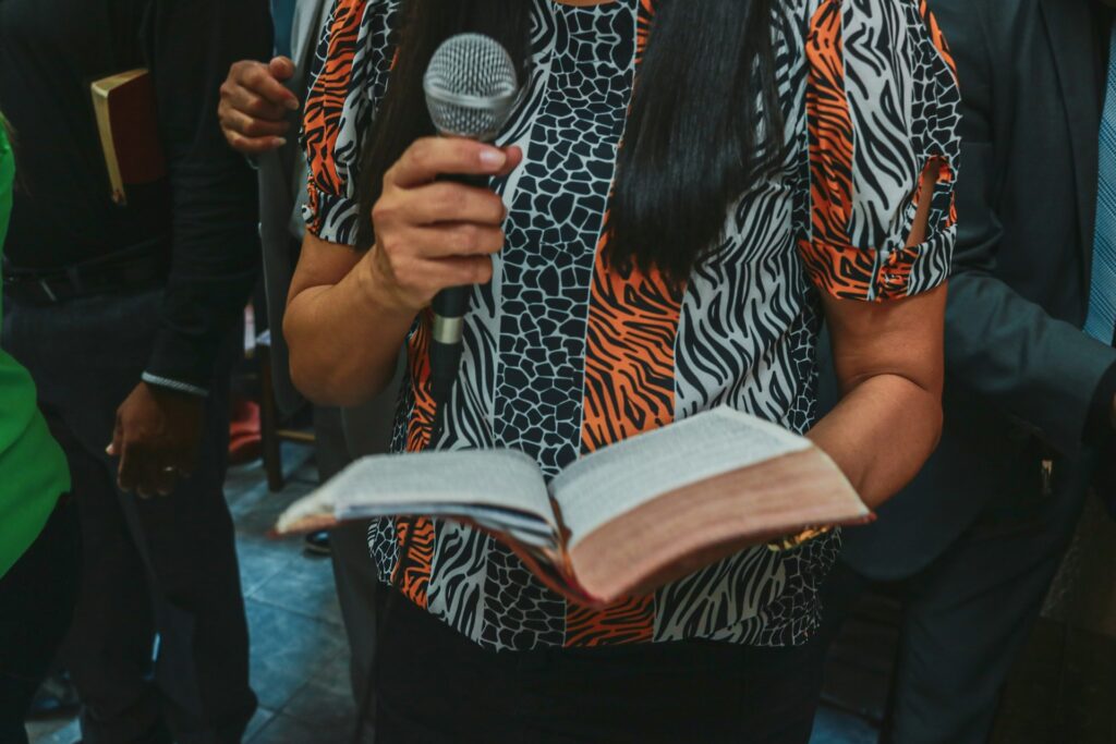 A woman holding a bible and microphone