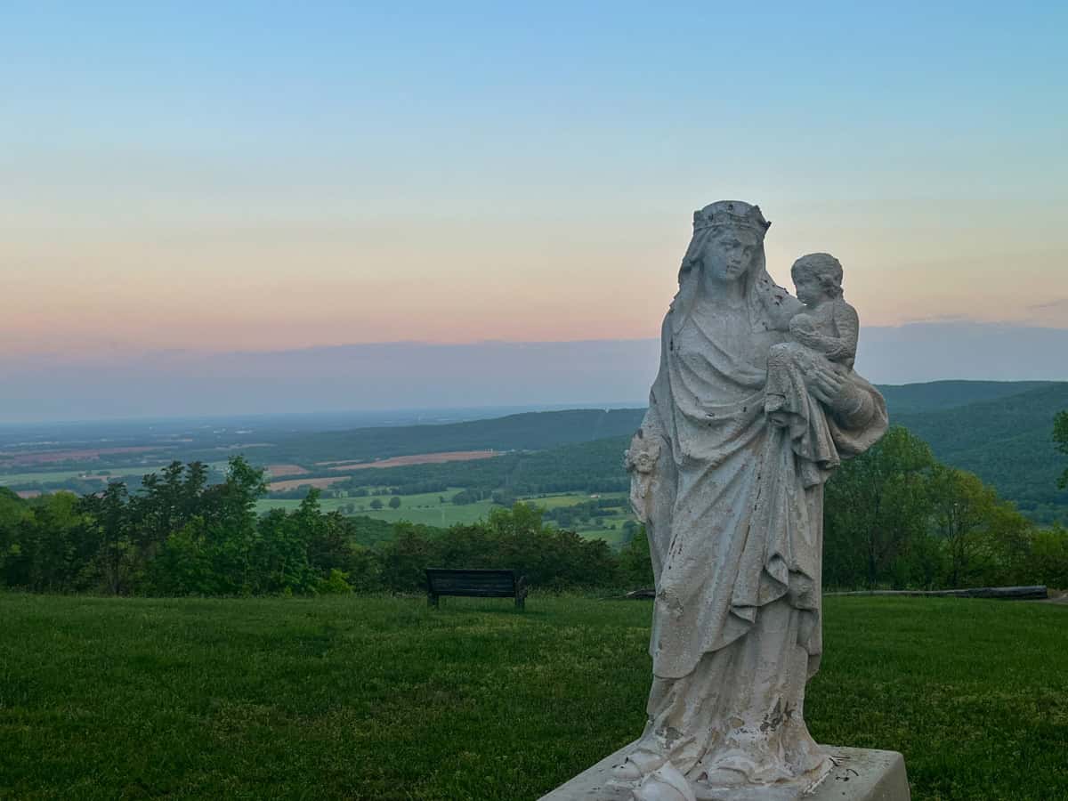 Mary and the Christ child statue with a sunrise behind. St. Mary's Sewanee