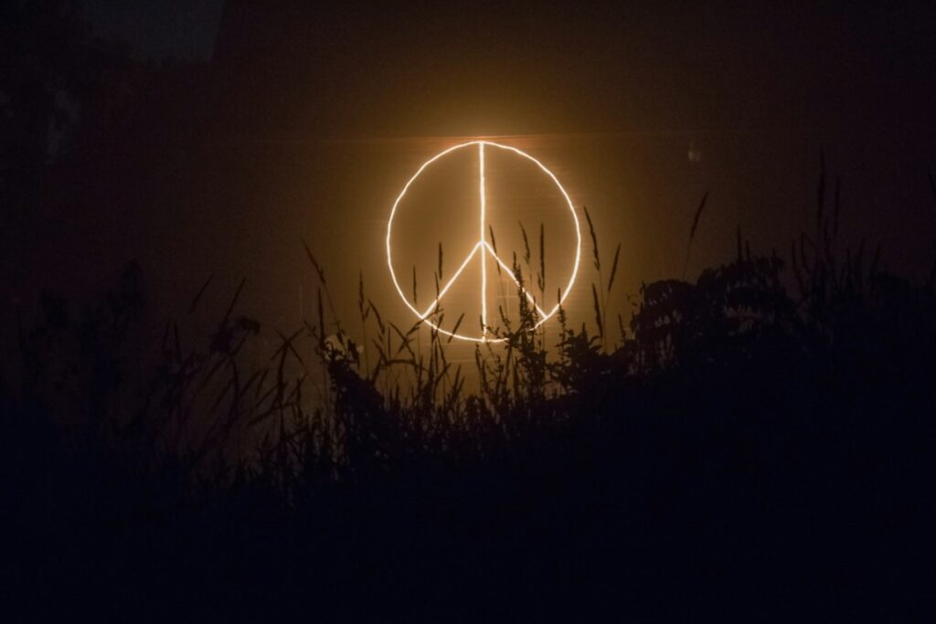 A peace sign in yellow light.