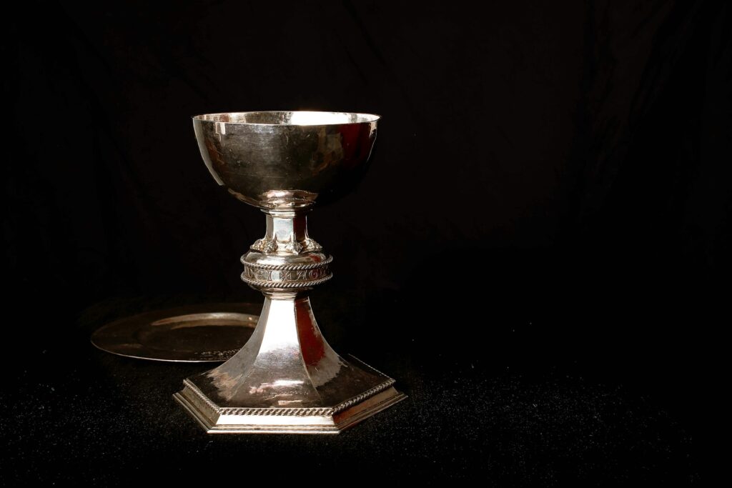 A silver chalice against a black background.