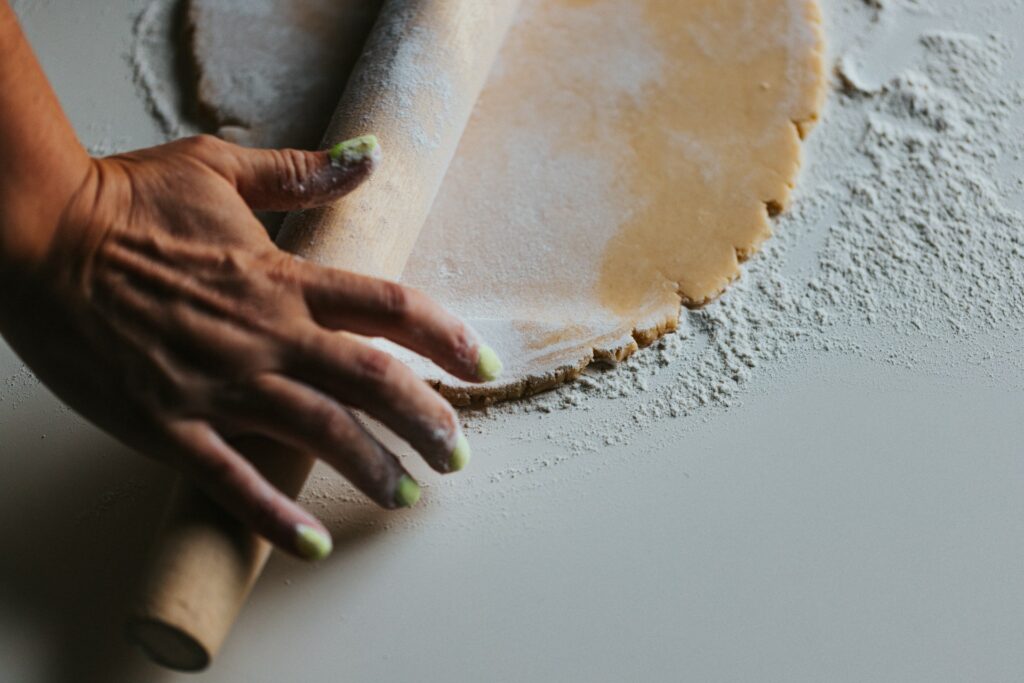 A woman rolling out a pie crust.