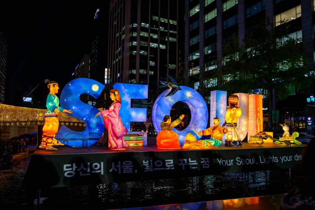 A lit sign at night spelling SEOUL.