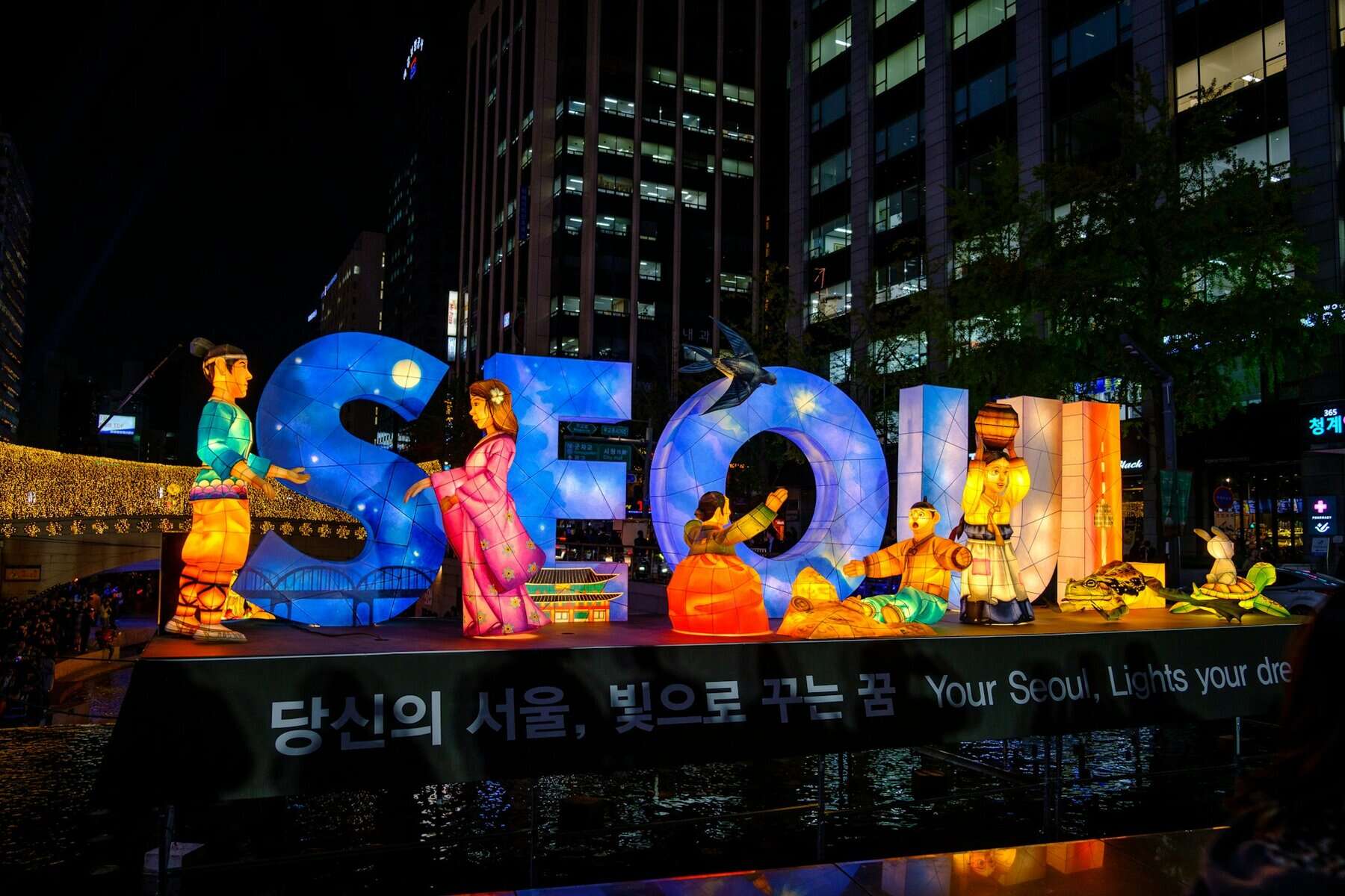 A lit sign at night spelling SEOUL.