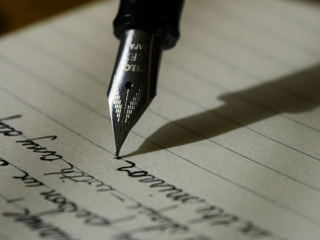 Bear Grylls calls new book on Jesus his greatest adventure A calligraphy pen is shown poised to continue writing script.