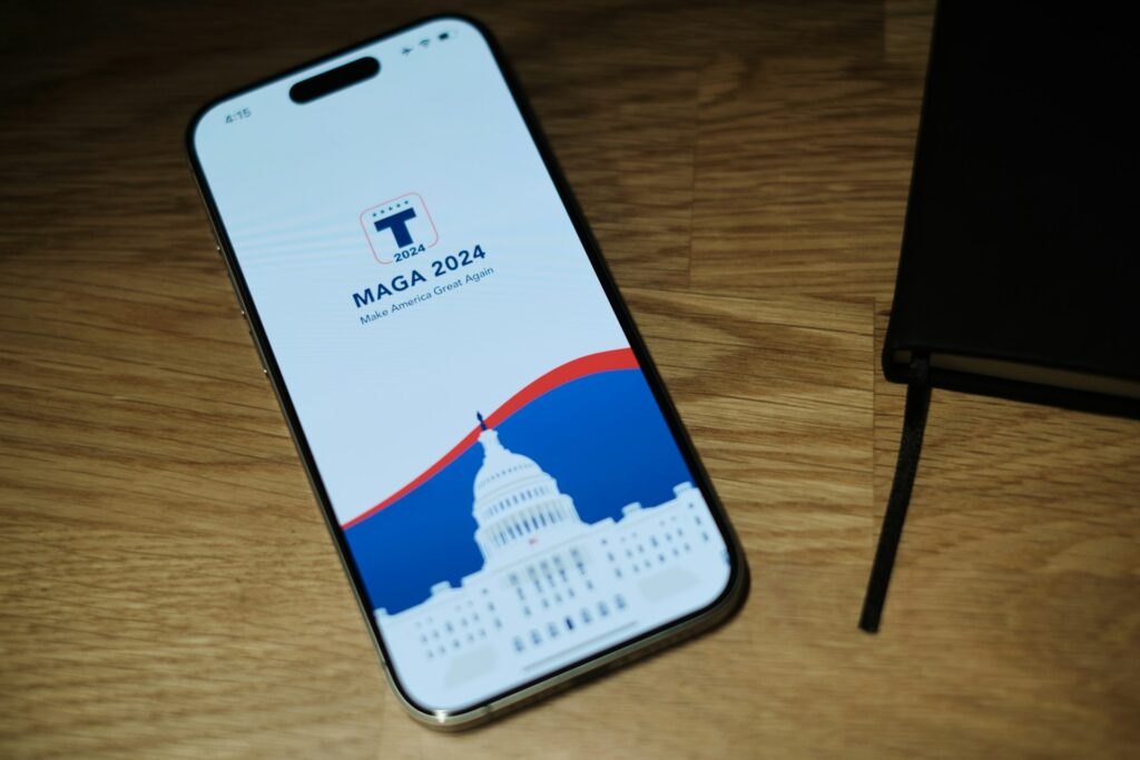 A phone with a MAGA site showing sitting next to a bible. Evangelicals leaving MAGA.