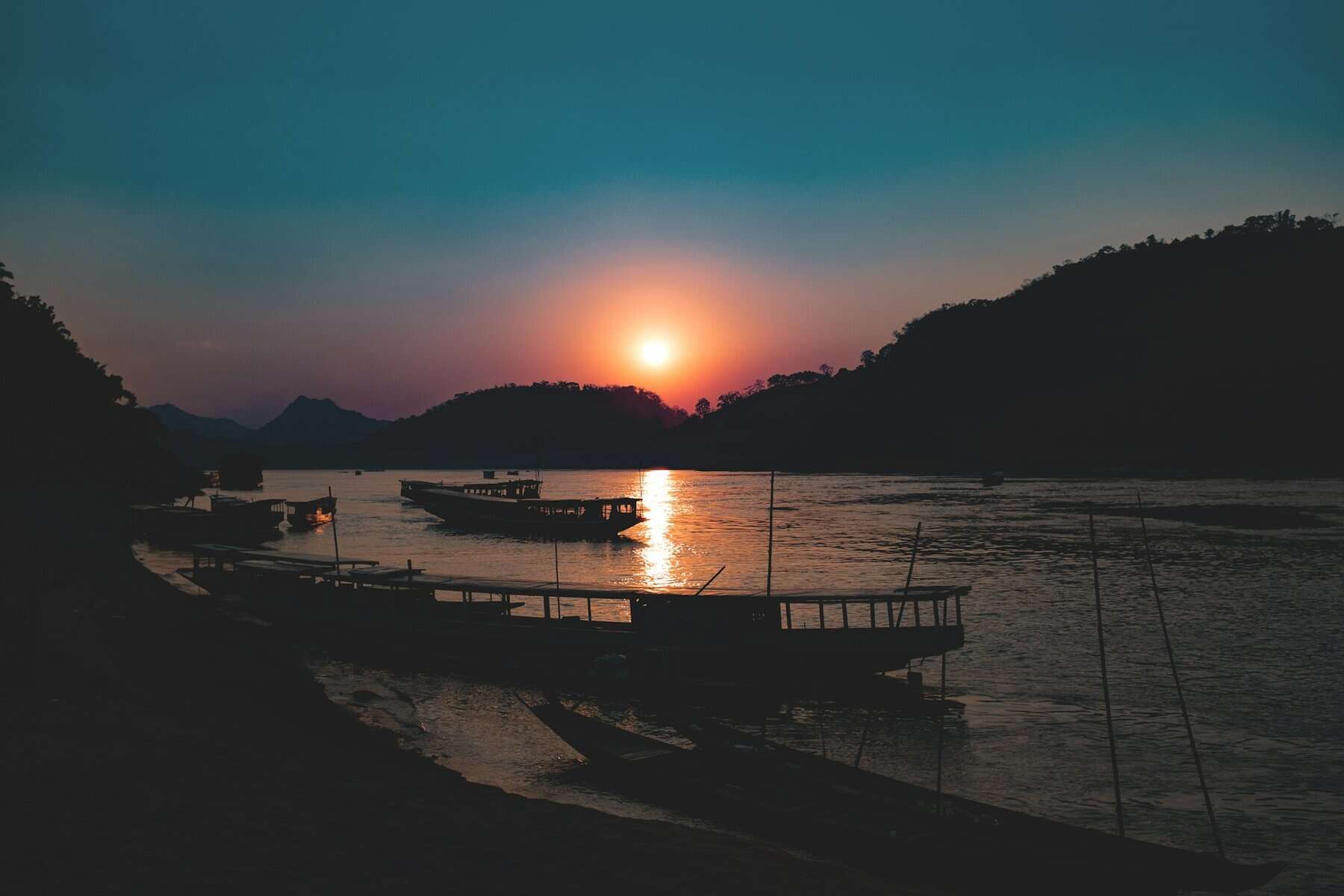 Boats on a river at sunset in Loas.