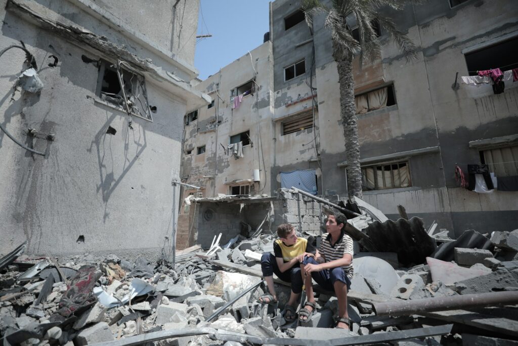 Two boys sitting on building rubble in Gaza.