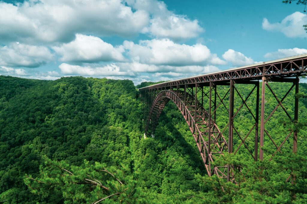 A railroad trestle bridge over a wooded hillside.