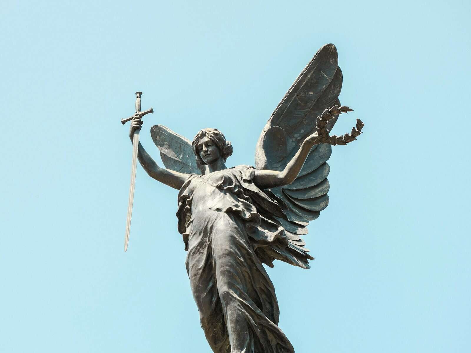 Statue of a woman holding a wreath and a sword.