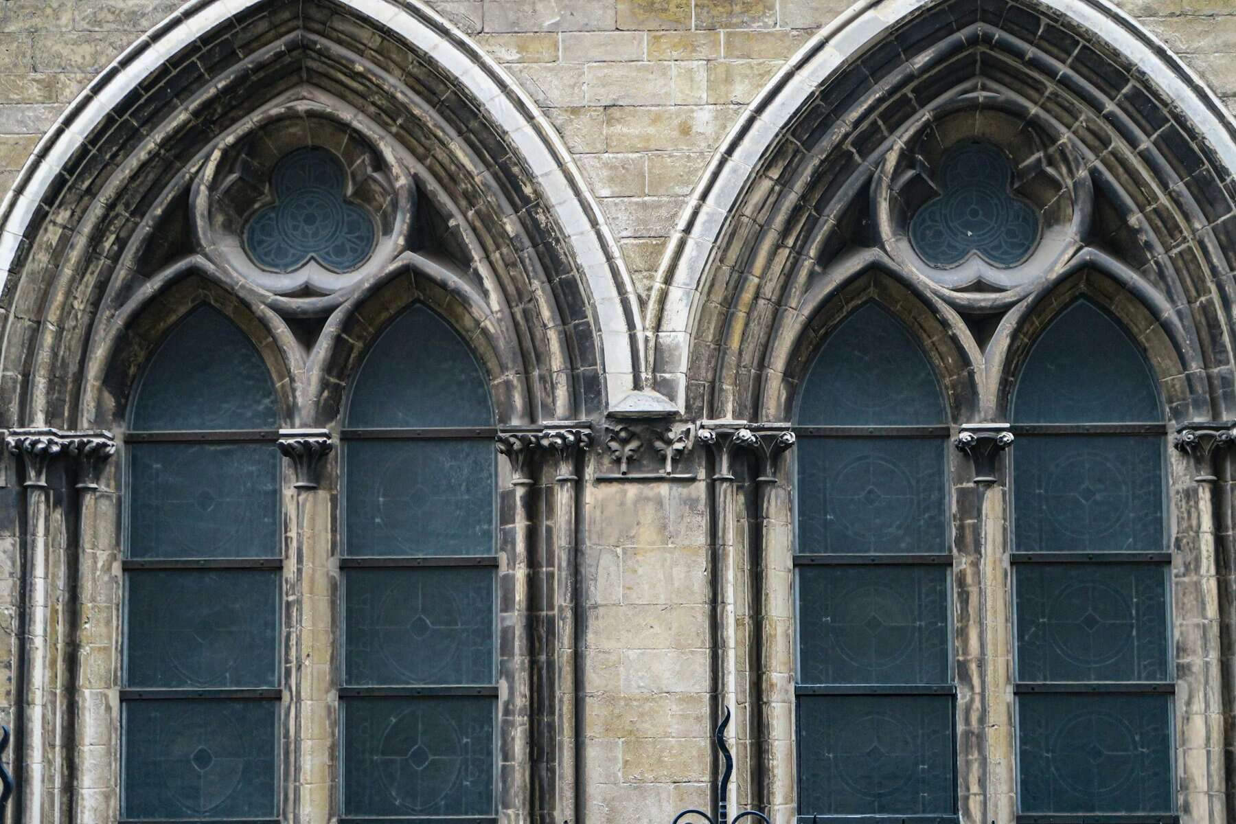 A pair of large church stained glass windows from the outside.