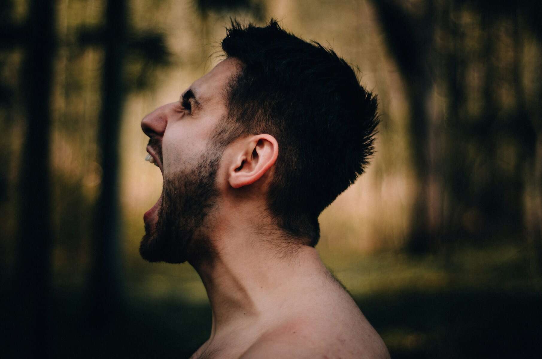 A screaming man's face shown from the side.