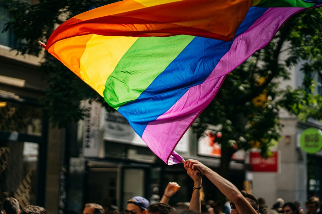 A person waves a LGBTQ pride flag.