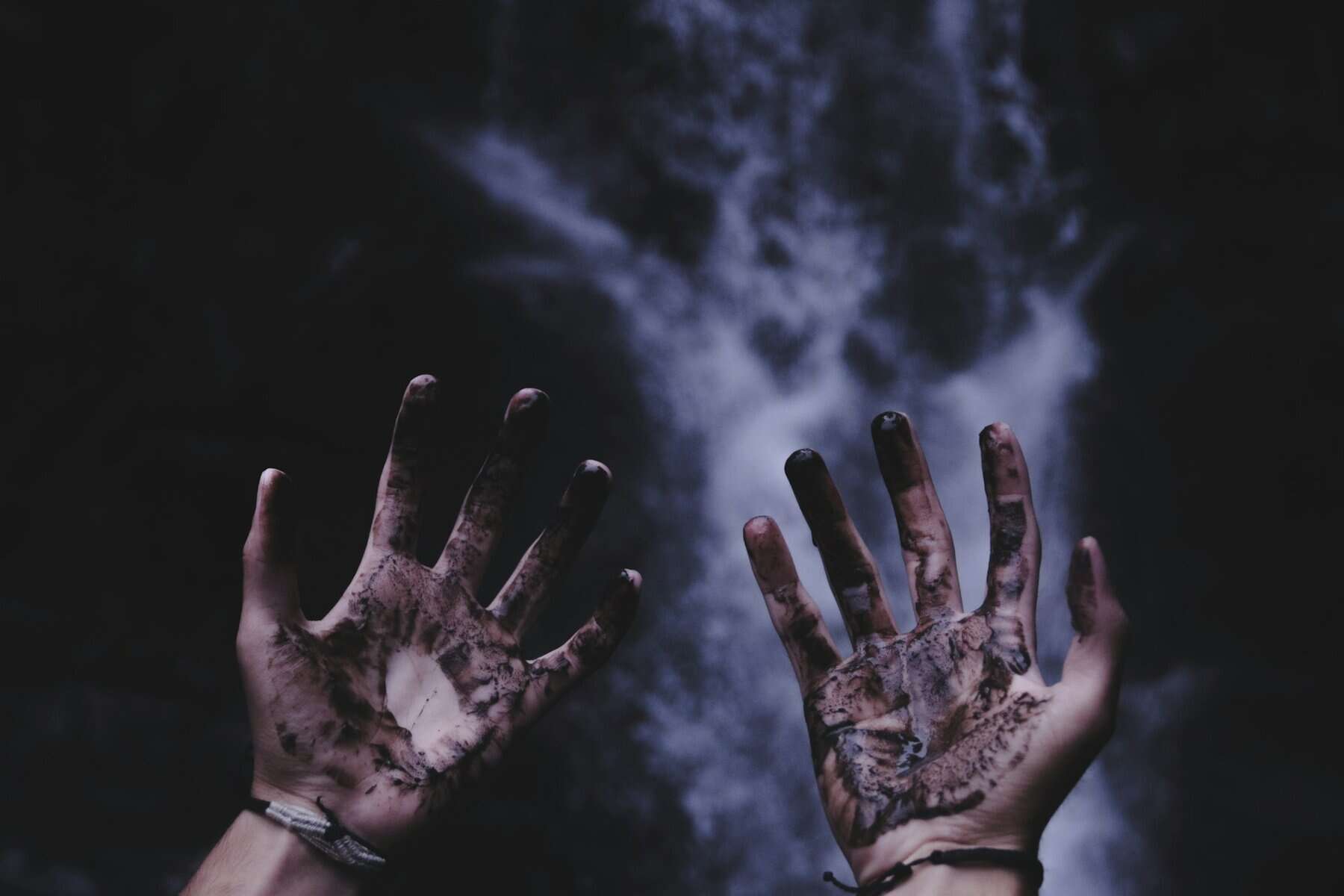 Filthy hands shown palm forward.