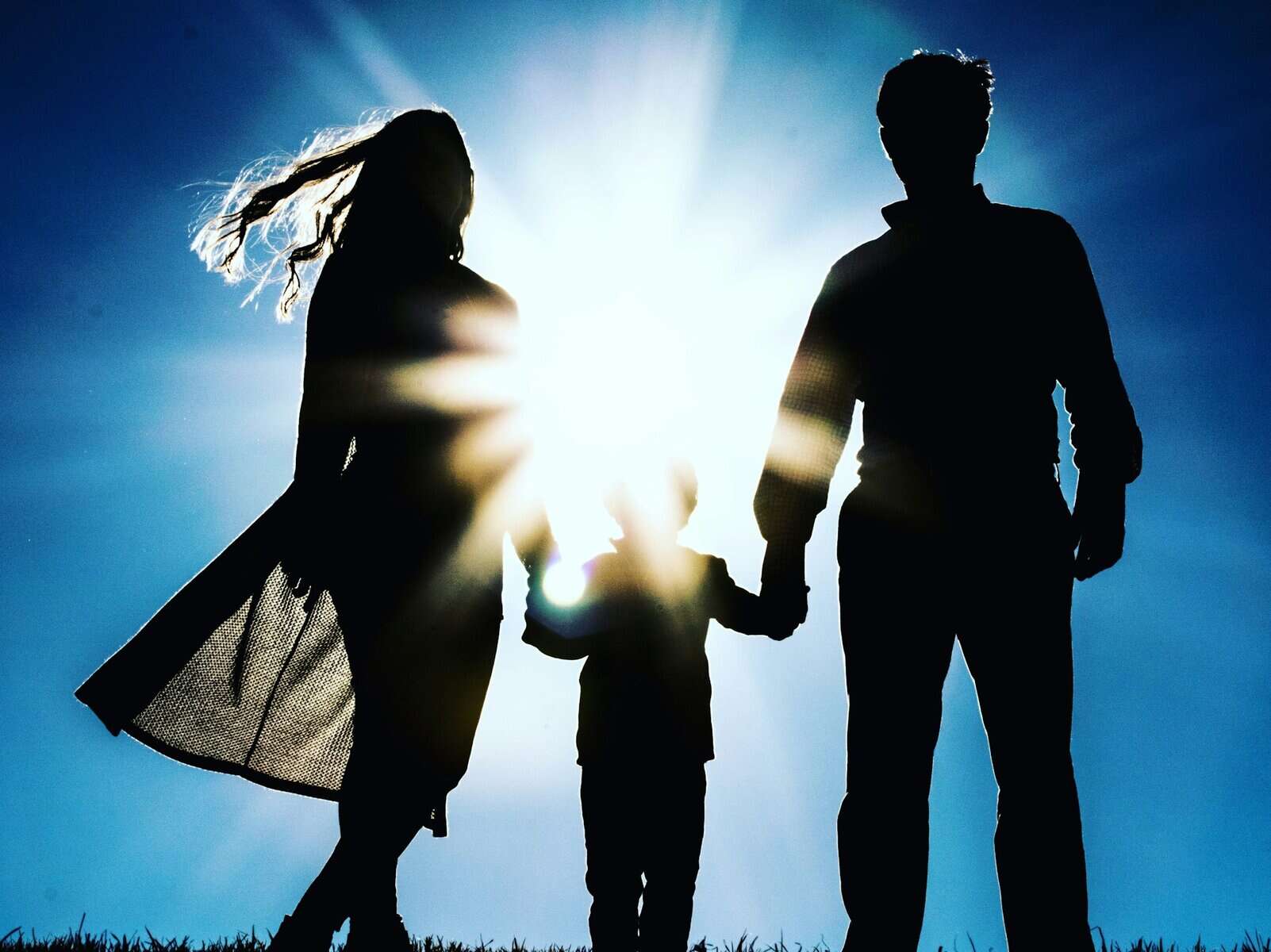 Silhouette of a man, child, and woman.