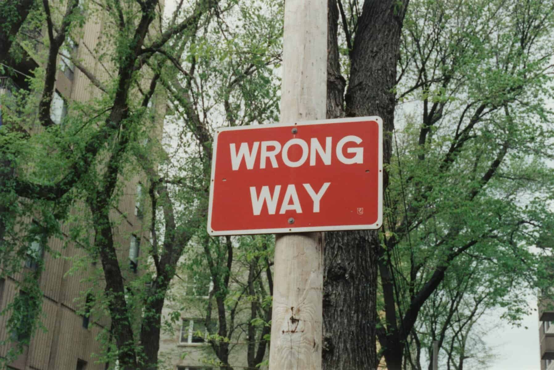 A red wrong way sign on a post.