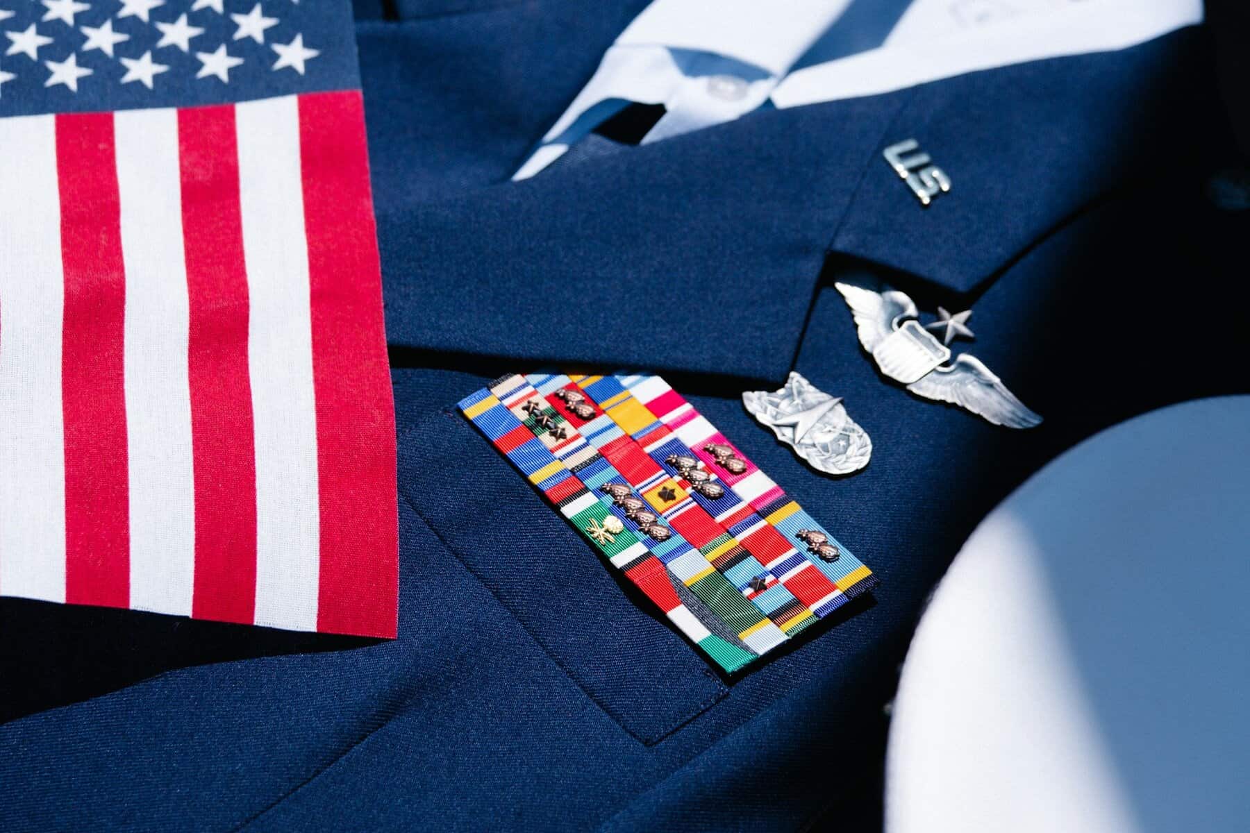A blue US military blazer with bars and pins with an American flag.