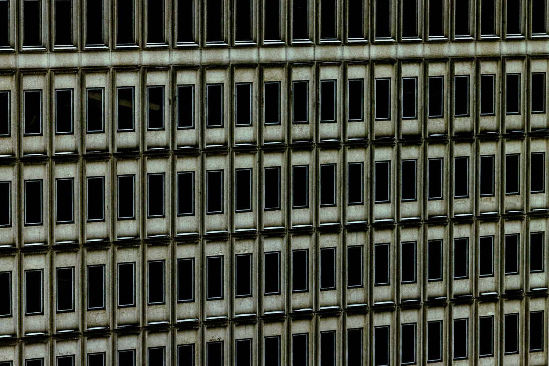 A concrete building's facade with rows of windows.