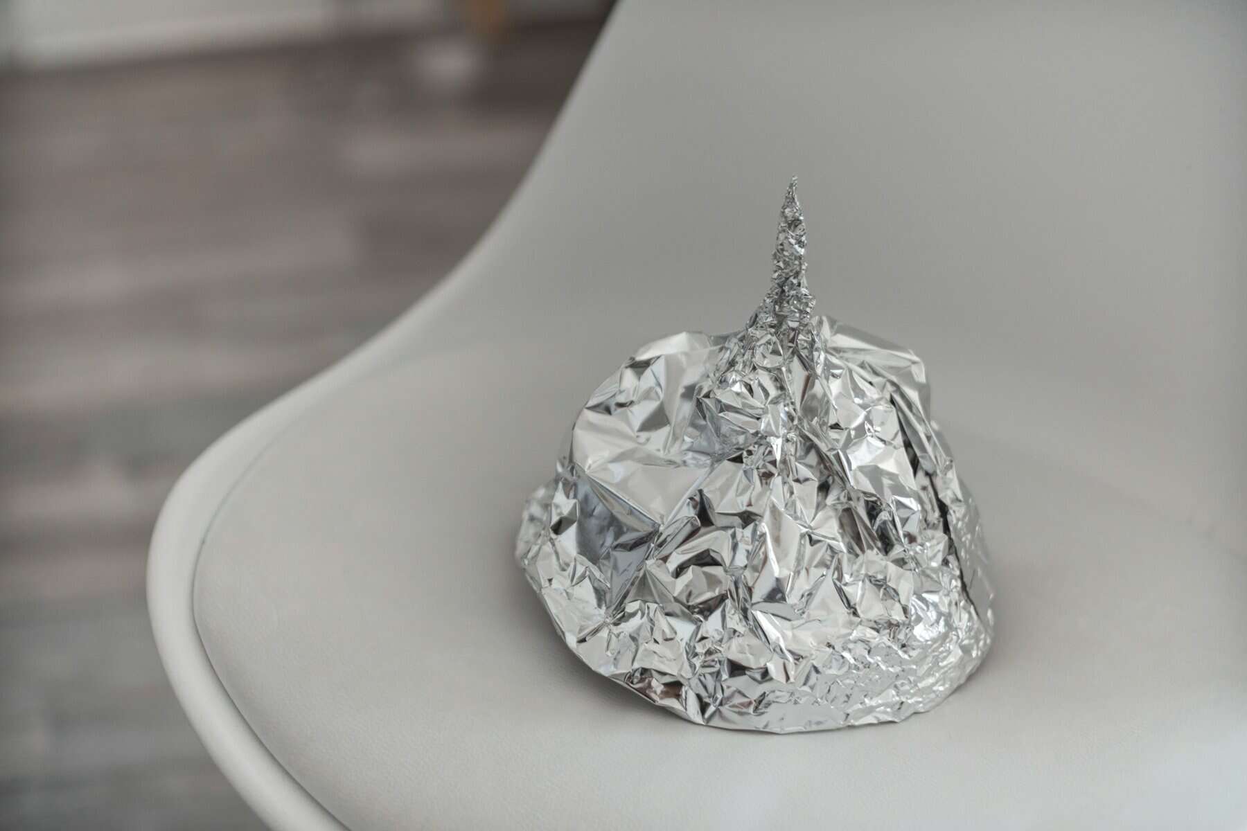 A tinfoil hat sits in a chair.